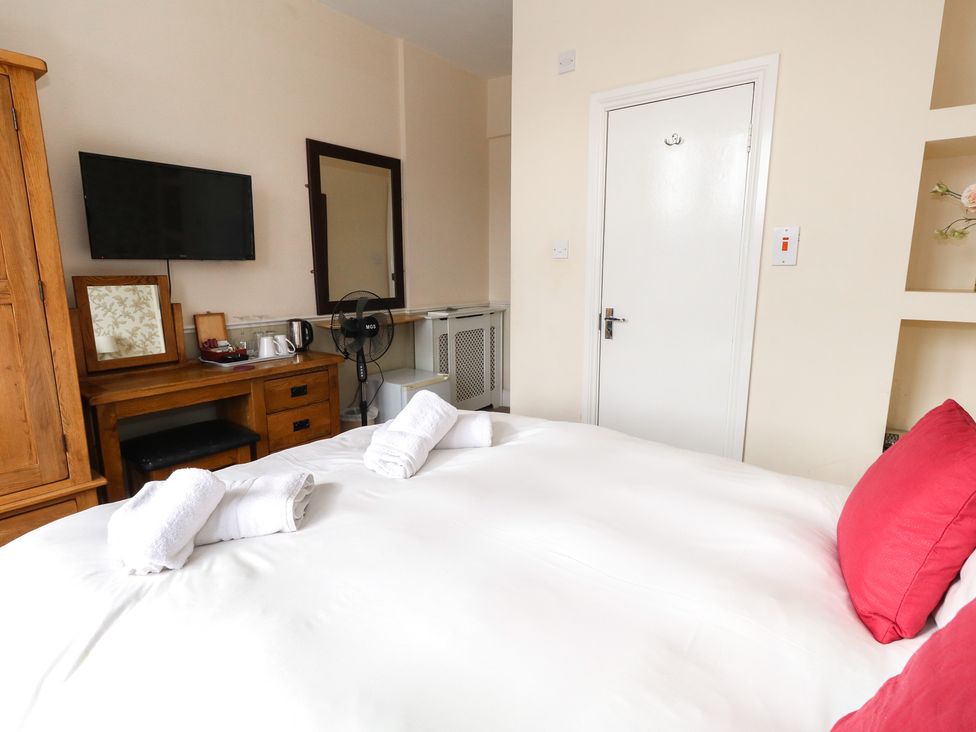 A bedroom with a bed, furniture and a television at 9 The Esplanade 