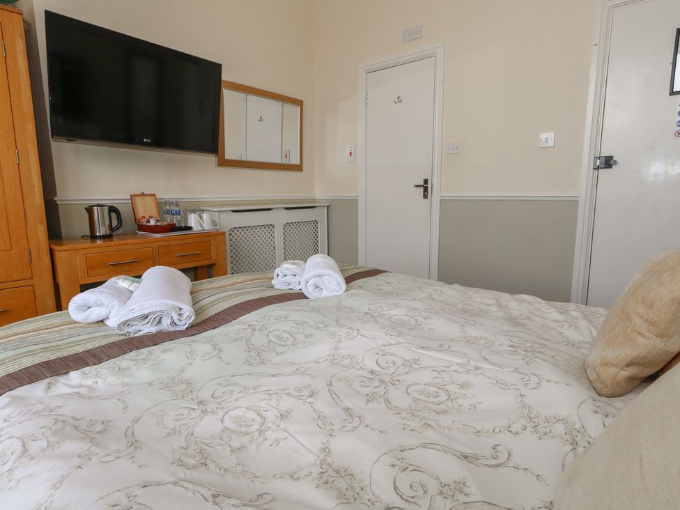 A bedroom with a bed, television, and kettle at 9 The Esplanade 