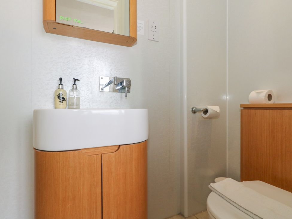 A bathroom with a sink and a mirror at 9 The Esplanade 