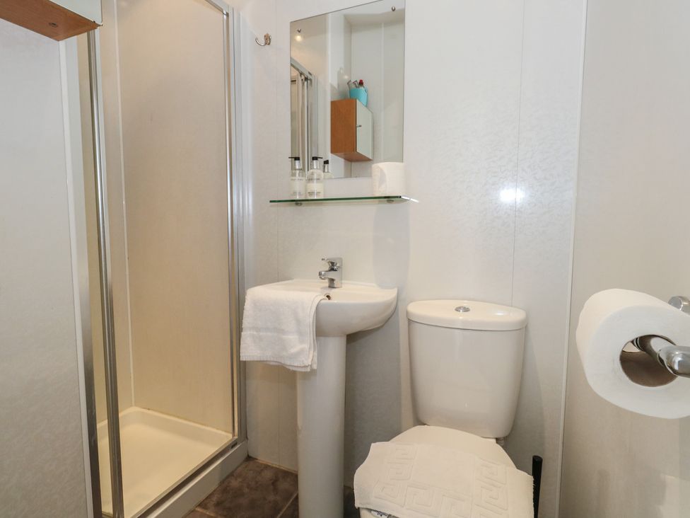 A bathroom with a shower, sink, and toilet at 9 The Esplanade