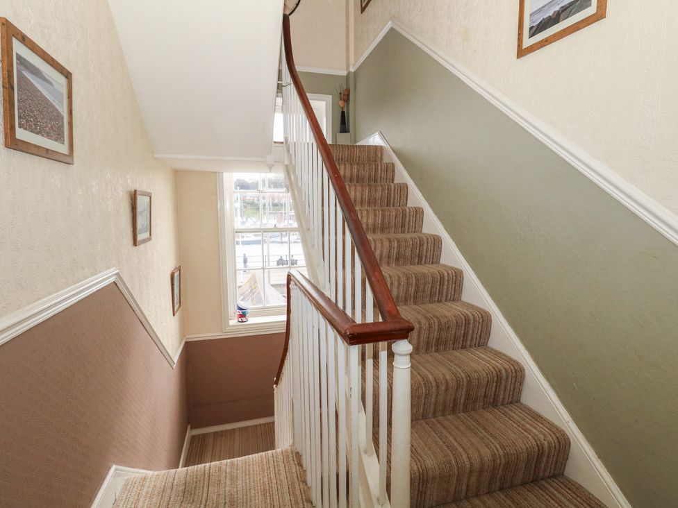 A staircase with framed pictures and a window at 9 The Esplanade