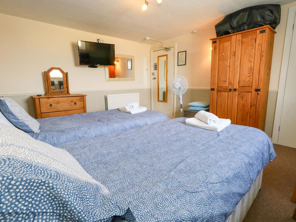 A bedroom with two beds and a wardrobe at 9 The Esplanade in Weymouth