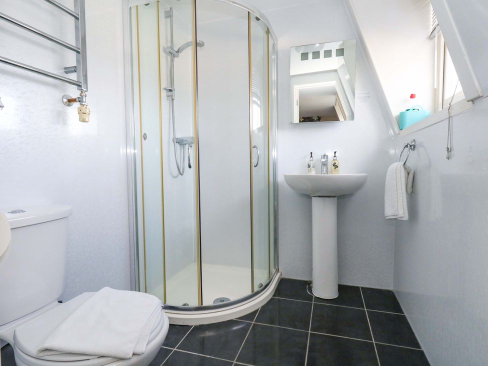 A bathroom with a shower, toilet, and sink at 9 The Esplanade in Weymouth