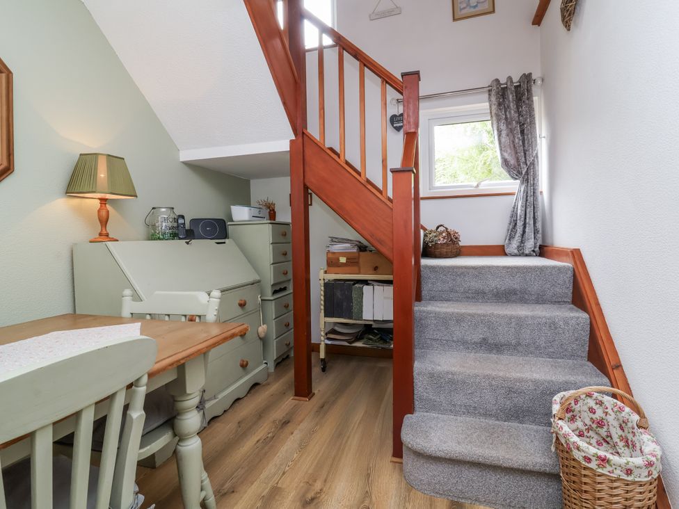 A dining area with a staircase and lamp at Ocean Cottage Bude