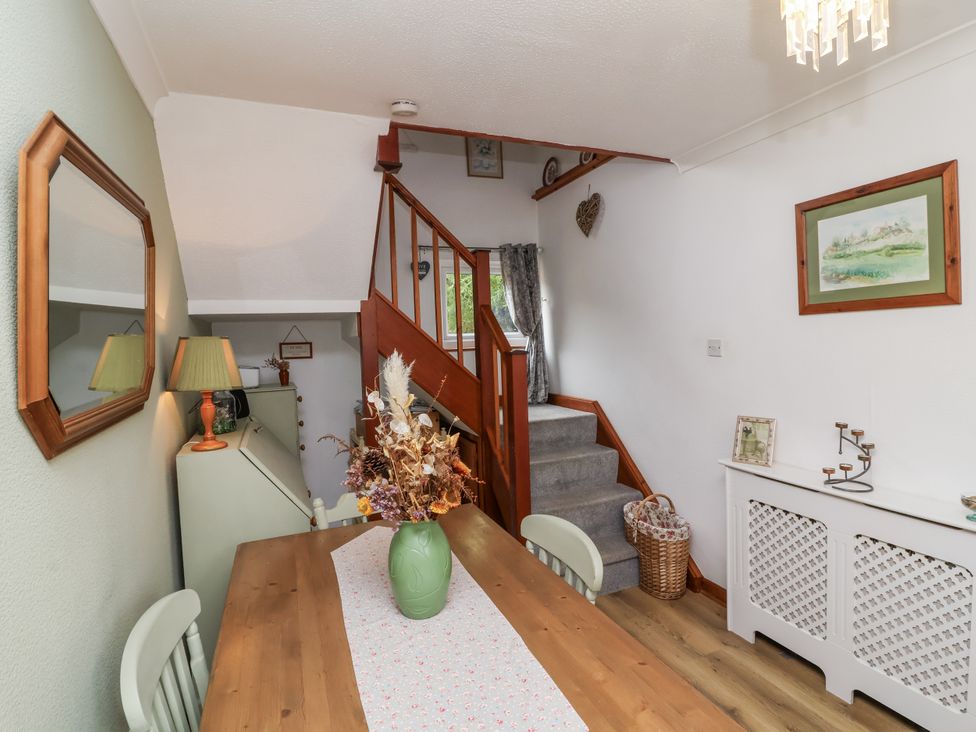 A dining room with a table and flowers at Ocean Cottage in Bude