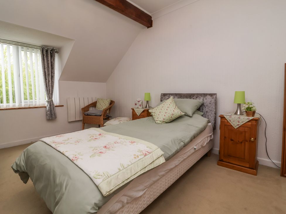 A bedroom with a bed and nightstands at Ocean Cottage in Bude