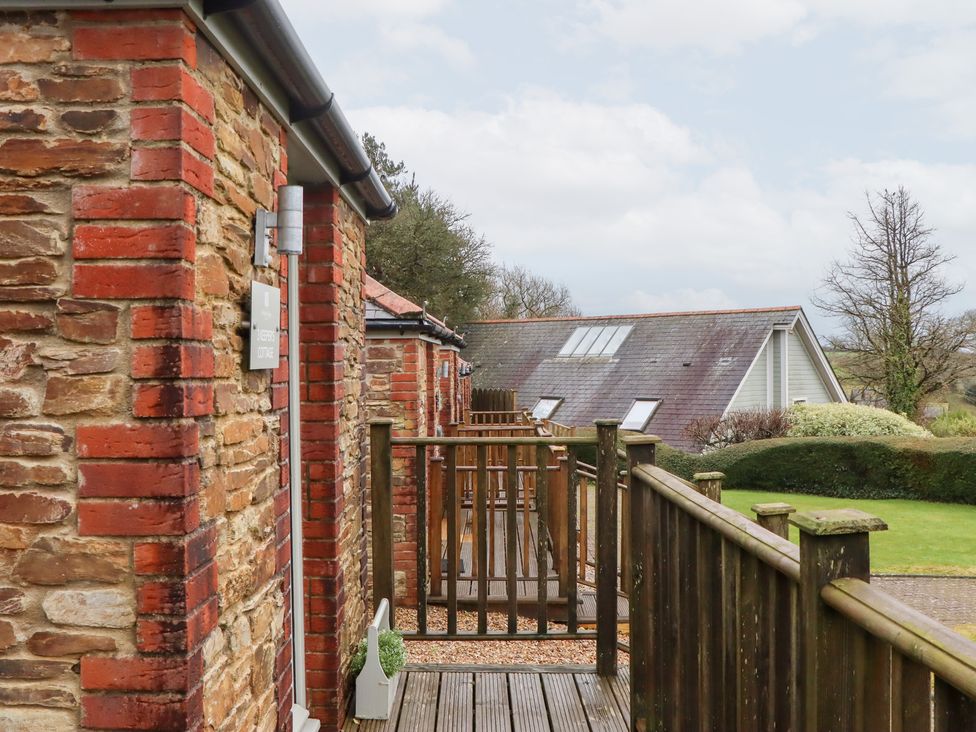 An outdoor area with a wooden deck and brick walls at 3 Keepers Cottage