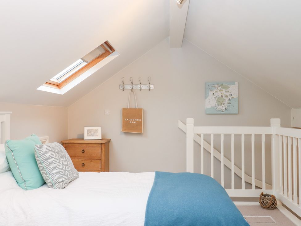 A bedroom with a bed and wall art at 3 Keepers Cottage