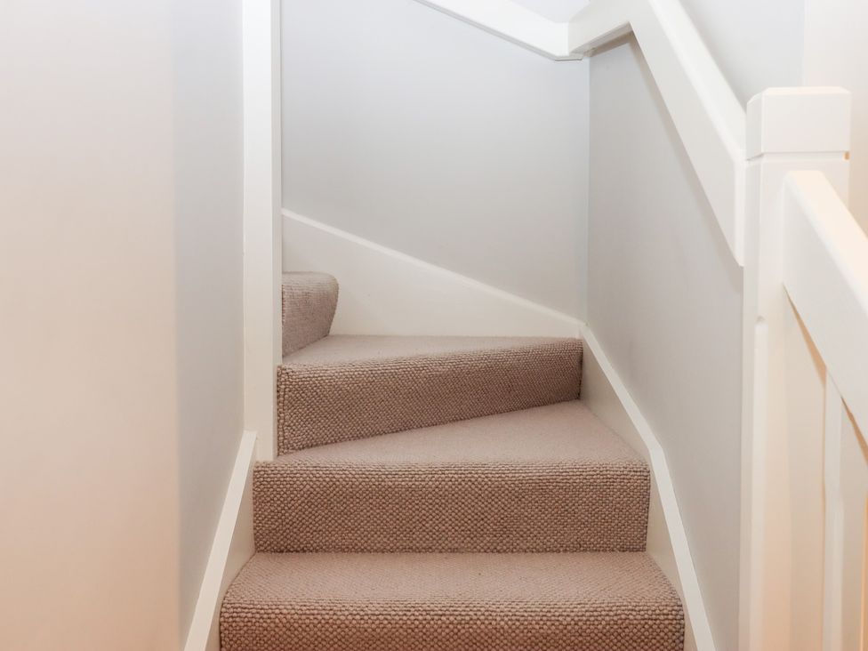 A staircase with carpeted steps at 3 Keepers Cottage