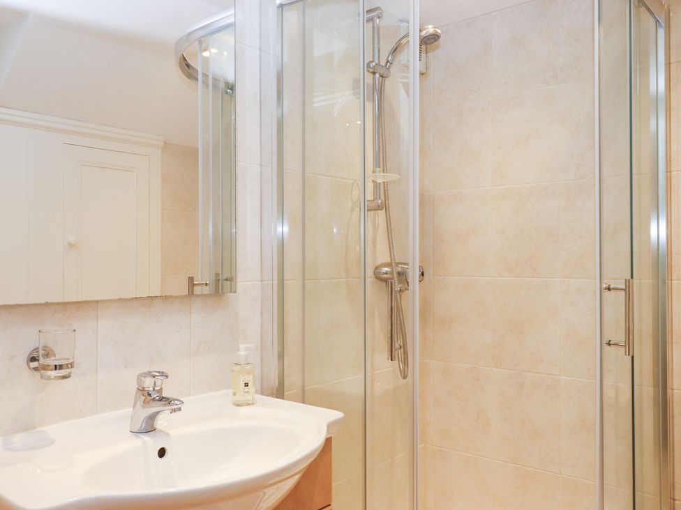 A bathroom with a shower and sink at 3 Keepers Cottage