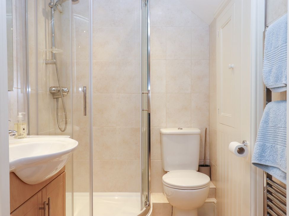 A bathroom with a shower, toilet, and sink at 3 Keepers Cottage