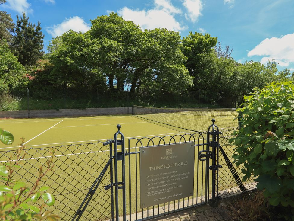 A tennis court with a gate and rules sign at 3 Keepers Cottage in 