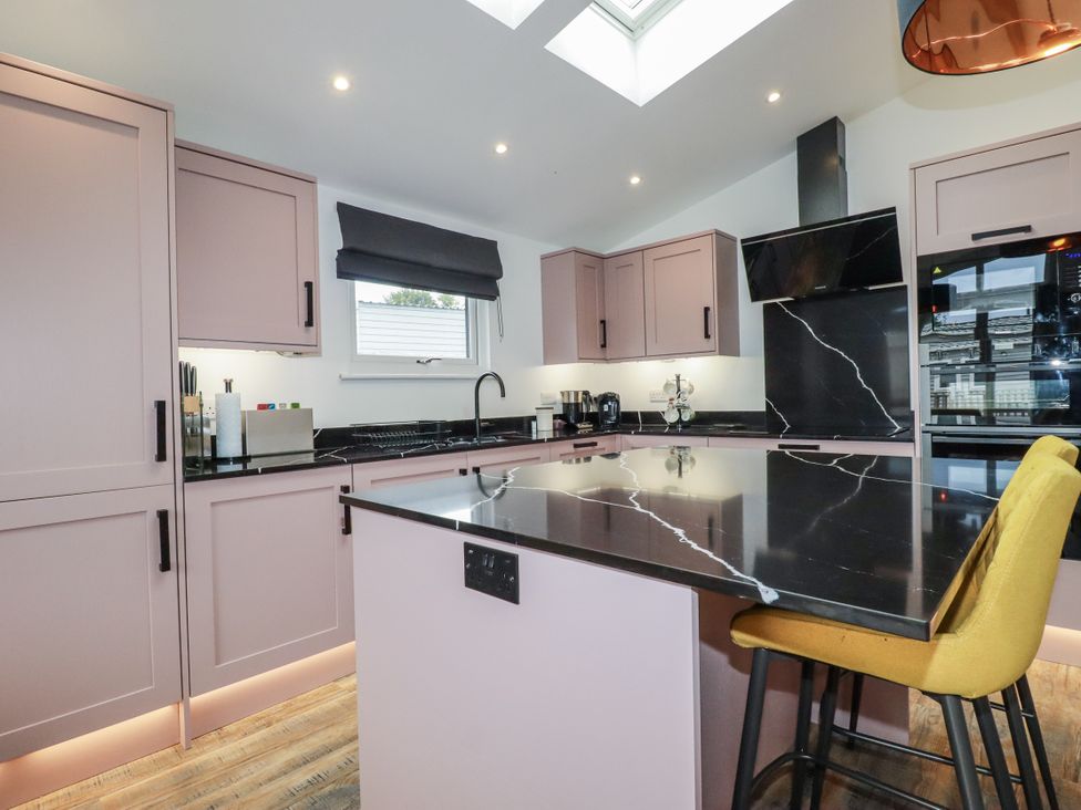 A kitchen with cabinets and an island at Minack Lodge Redruth