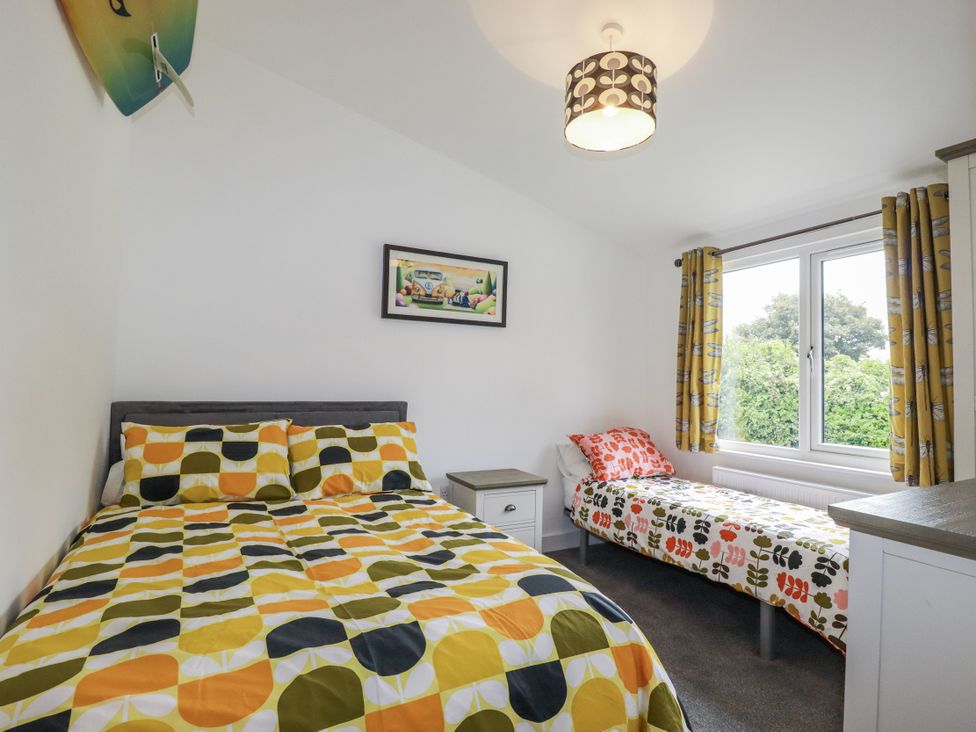 A bedroom with a double bed and a single bed at Minack Lodge Redruth