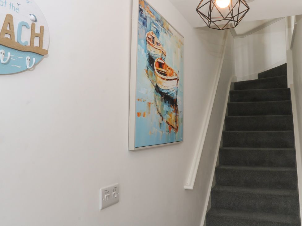 A hallway with a painting and stairs at Beach House Seaside Dunes in Lytham St. Annes