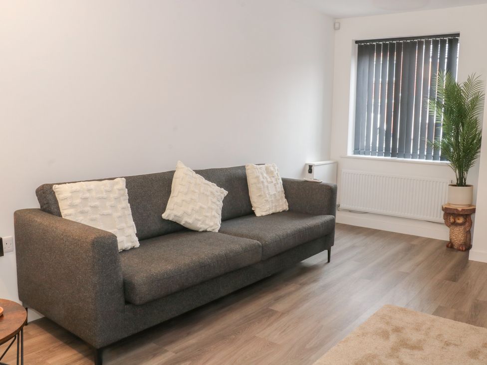 A living room with a sofa and window at Beach House Seaside Dunes Lytham St. Annes