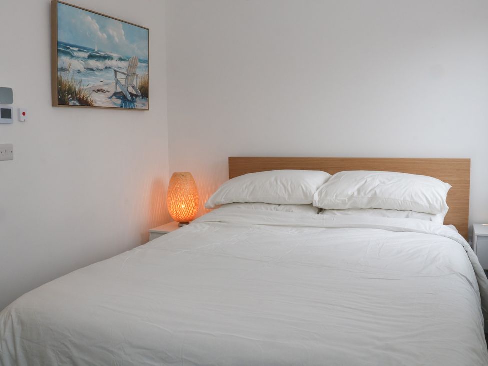 A bedroom with a bed and bedside table at Beach House Seaside Dunes in Lytham St. Annes