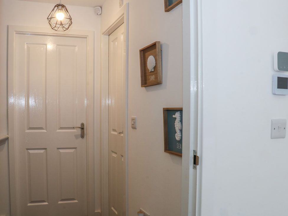 A hallway with doors and wall decorations at Beach House Seaside Dunes in Lytham St. Annes