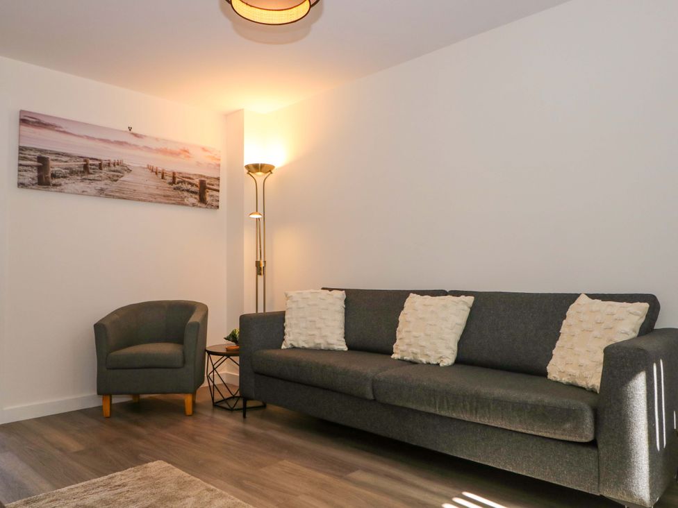 A living room with a sofa and an armchair at Beach House Seaside Dunes in Lytham St. Annes