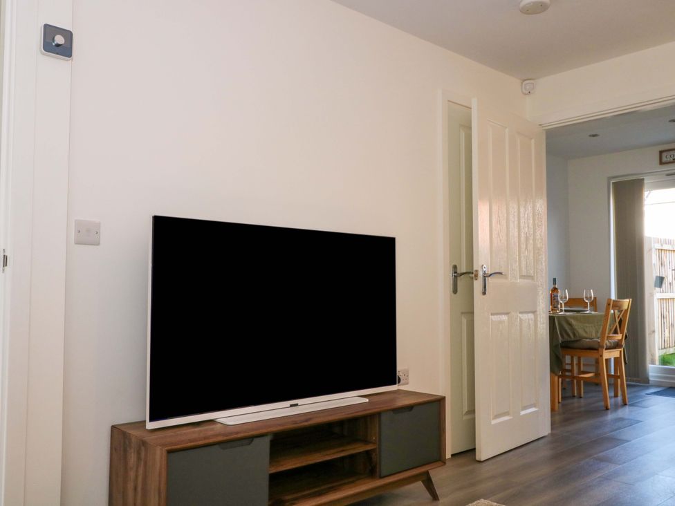 A living room with a television and dining area at Beach House Seaside Dunes in Lytham St. Annes
