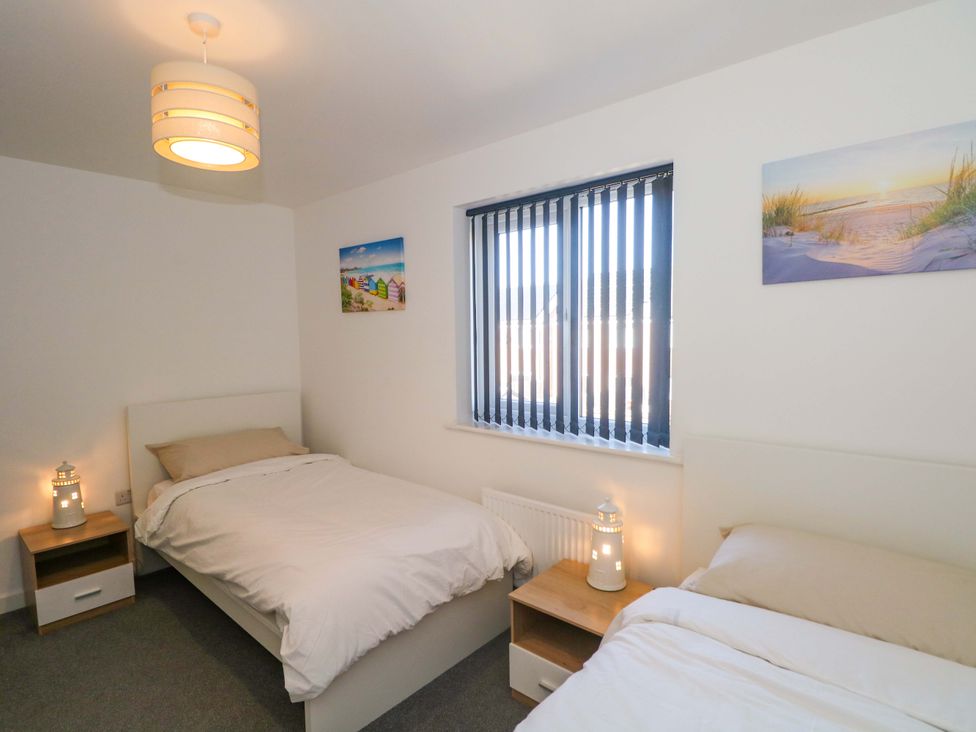 A bedroom with two beds and a window at Beach House Seaside Dunes in Lytham St. Annes