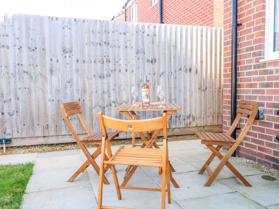 A patio with a table and chairs at Beach House Seaside Dunes in Lytham St. Annes