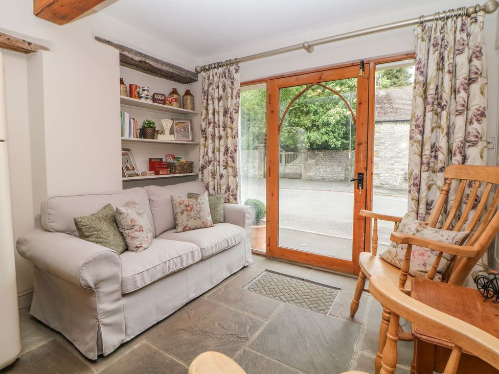 A living room with a sofa and a door leading outside at Billy Whiskey's, Tideswell