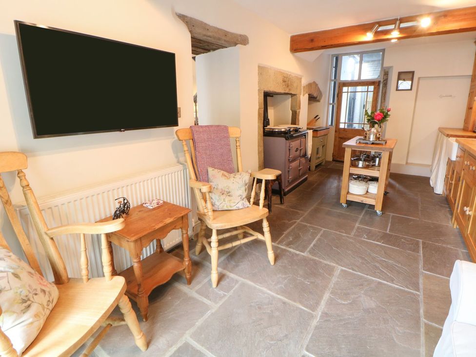 A kitchen with a television and wooden furniture at Billy Whiskey's in Tideswell