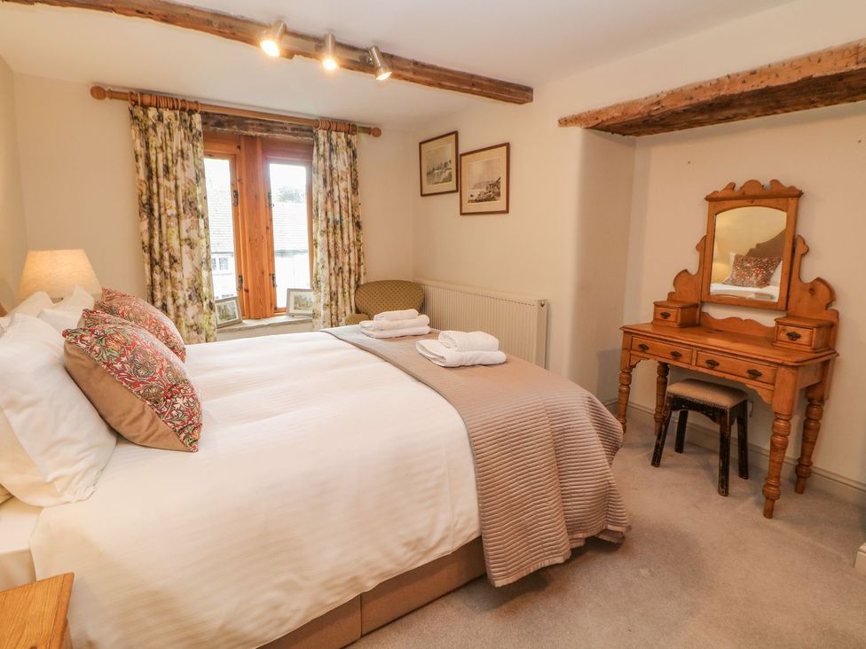 A bedroom with a bed and a dresser at Billy Whiskey's, Tideswell