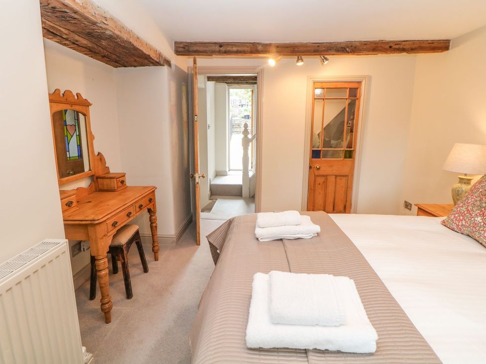 A bedroom with a bed and dressing table at Billy Whiskey's Tideswell