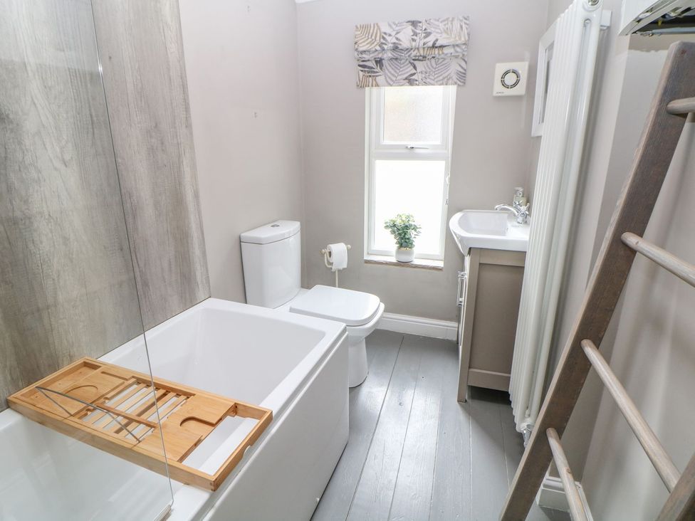 A bathroom with a bathtub, toilet, sink, and towel radiator at Billy Whiskey's in Tideswell