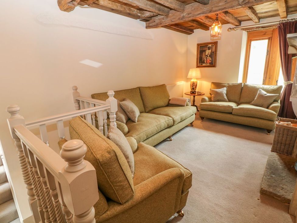 A living room with sofas and a lamp at Billy Whiskey's Tideswell