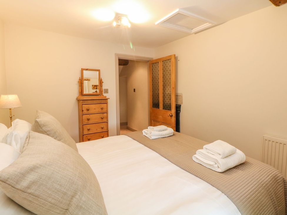 A bedroom with a bed and dresser at Billy Whiskey's, Tideswell