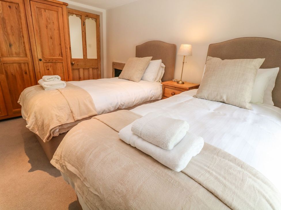 A bedroom with two beds and a wardrobe at Billy Whiskey's in Tideswell