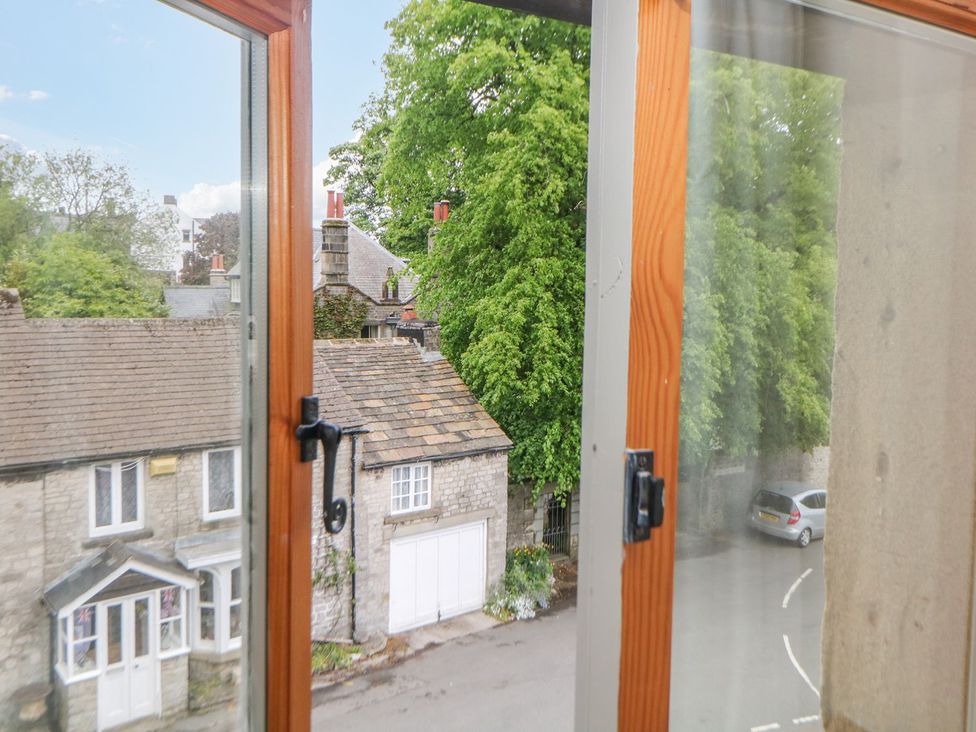 A view from a window showing trees and houses at Billy Whiskey's in Tideswell