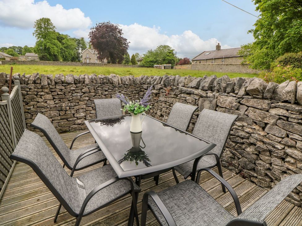 An outdoor seating area with a table and chairs at Billy Whiskey's in Tideswell