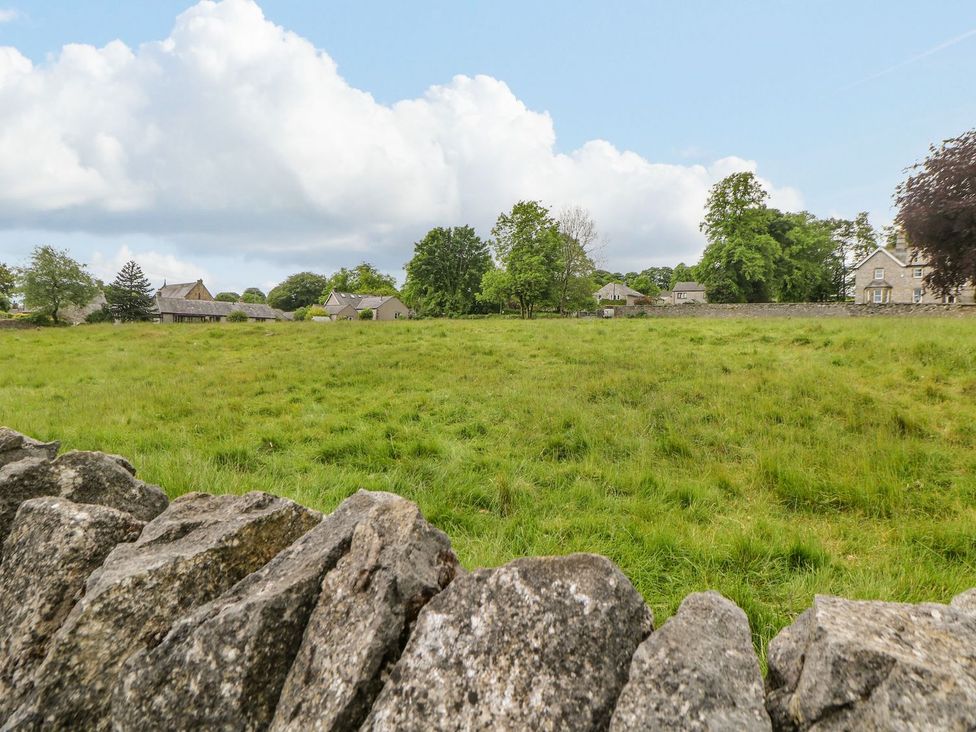An outdoor view of a grassy area with trees and houses at Billy Whiskey's Tideswell