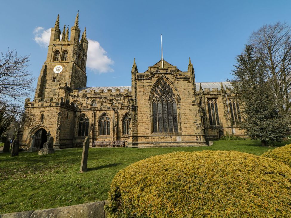 A church with a clock tower and stained glass windows at Billy Whiskey's in Tideswell