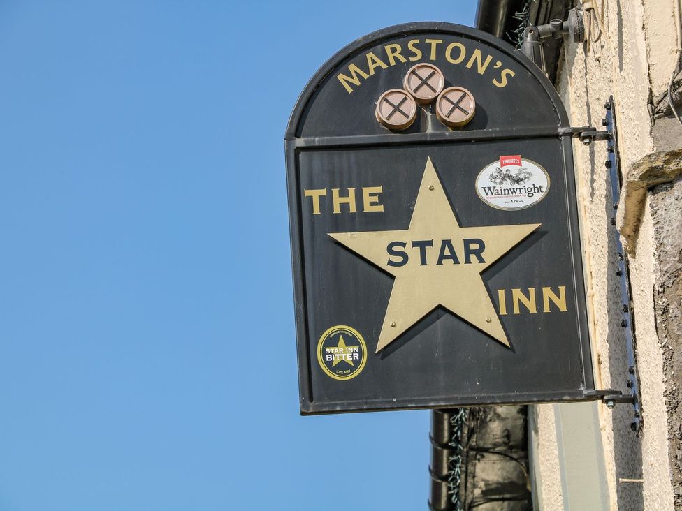 A sign for The Star Inn with a star graphic at Billy Whiskey's Tideswell