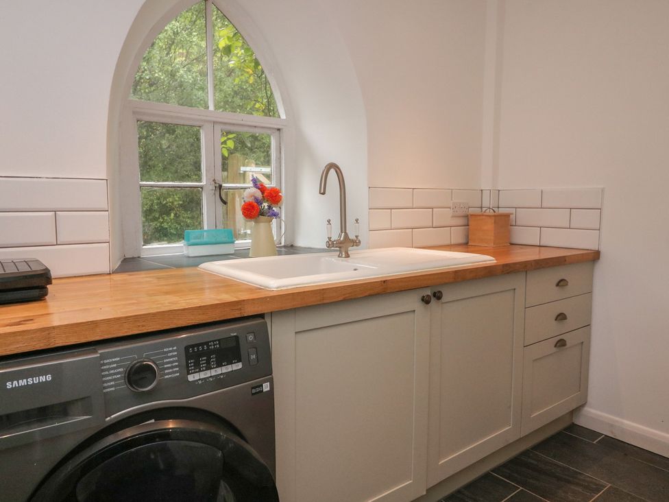 A kitchen with a washing machine and sink at Tapps Lodge in Plymouth