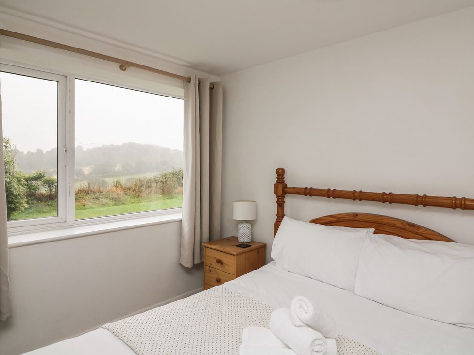 A bedroom with a bed and window at Tapps Lodge, Plymouth
