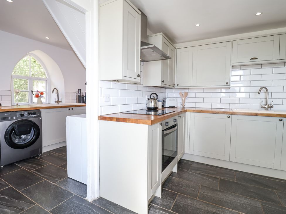 A kitchen with cabinets and appliances at Tapps Lodge Brixton near Yealmpton South Devon