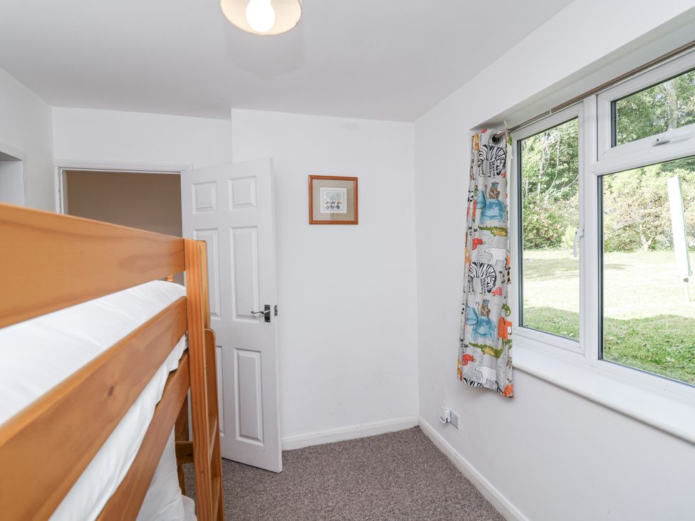 A bedroom with a bunk bed and window at Tapps Lodge in Brixton near Yealmpton, South Devon