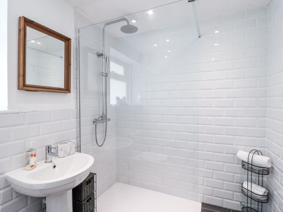 A bathroom with a shower, sink, and towels at Tapps Lodge Brixton near Yealmpton, South Devon