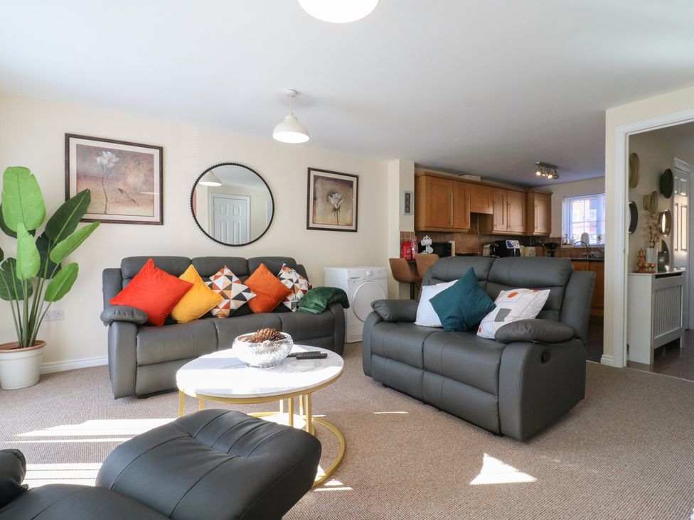 A living room with a sofa and cushions at Gem Relax