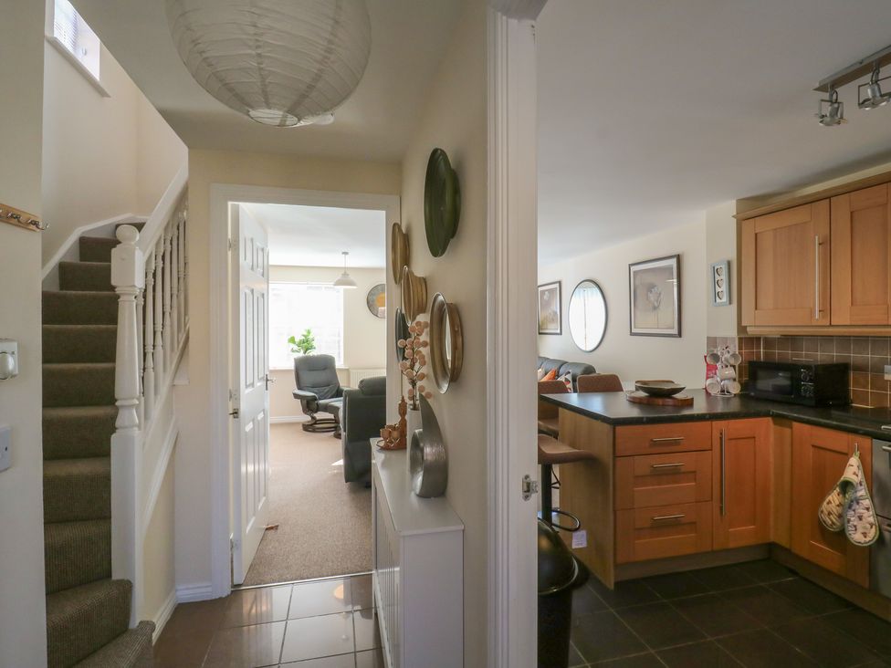 A hallway with a staircase and kitchen view at Gem Relax