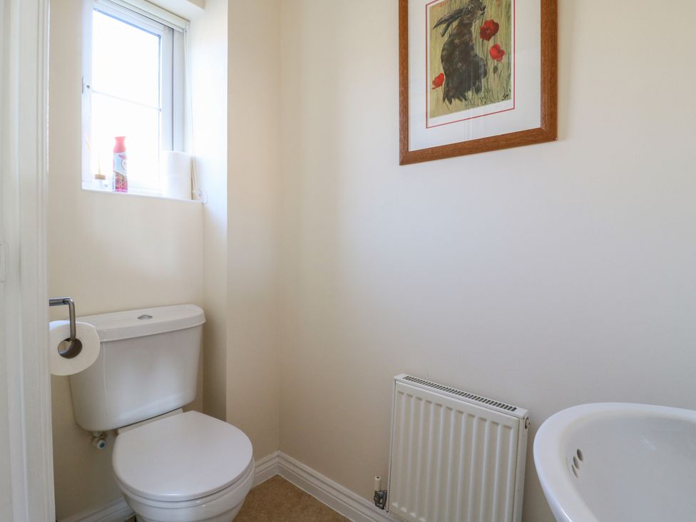 A bathroom with a toilet and framed artwork at Gem Relax