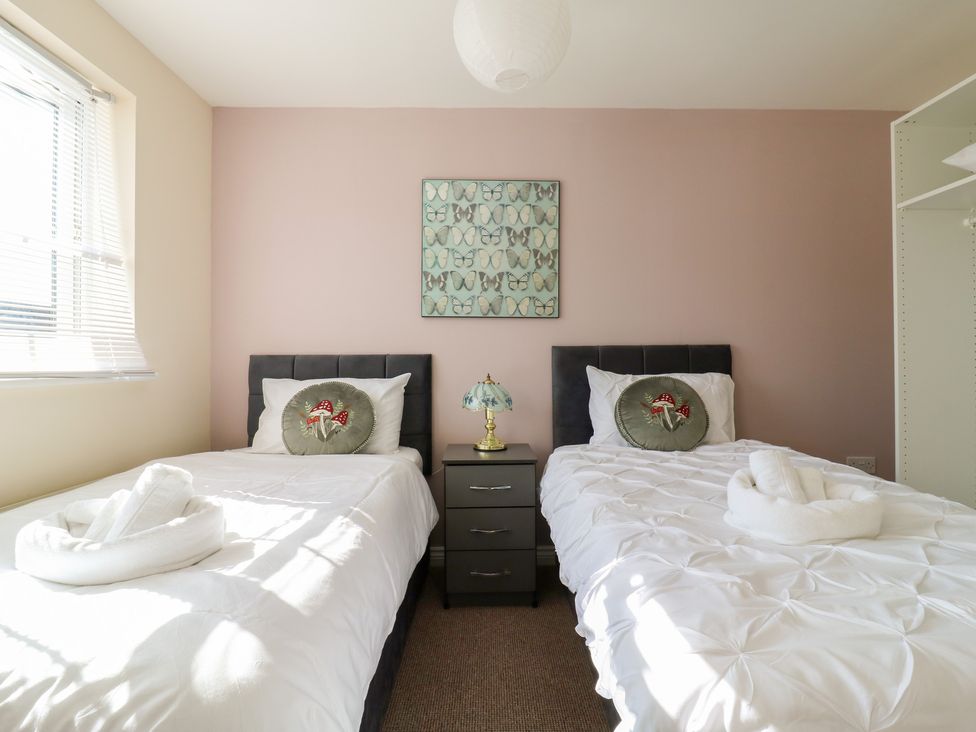 A bedroom with two beds and a lamp at Gem Relax