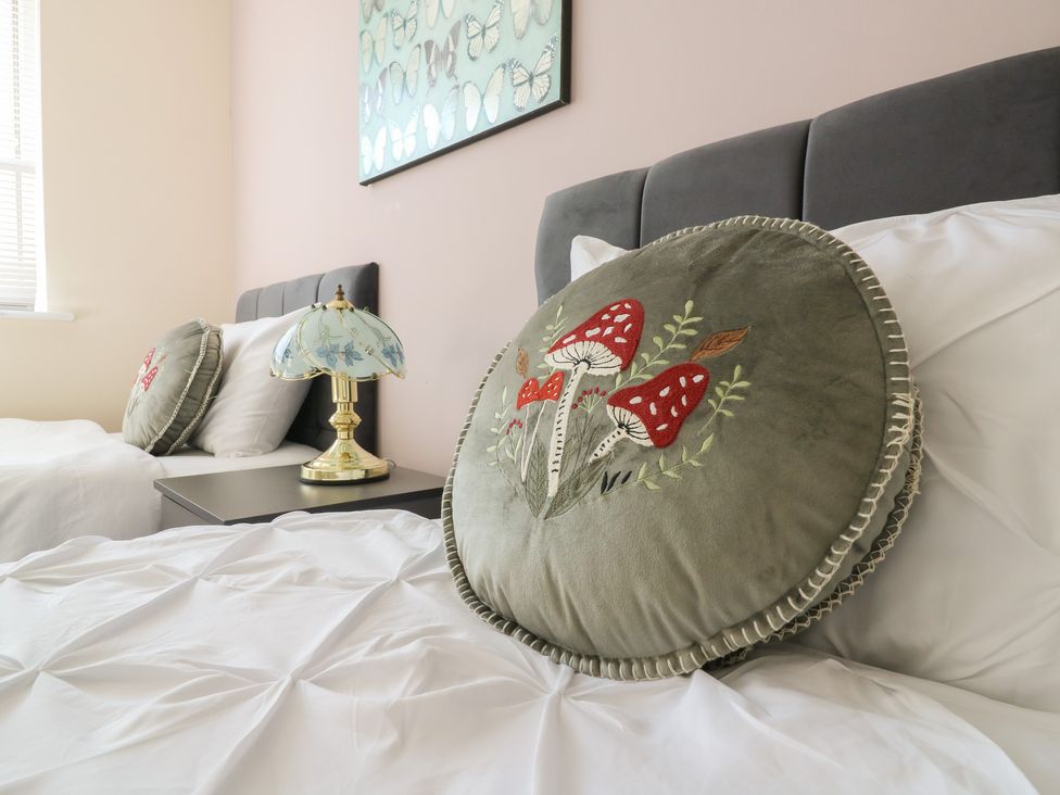 A bedroom with two beds and decorative pillows at Gem Relax