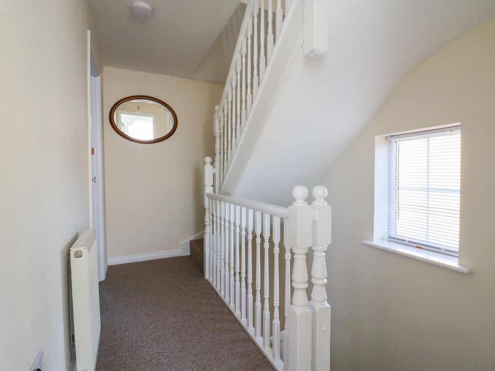 A hallway with a staircase and a mirror at Gem Relax